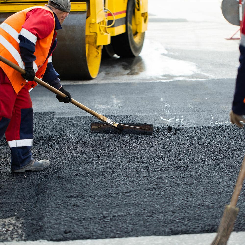 asphalt contractors paving over worn out and faded asphalt - Morgan Pavement